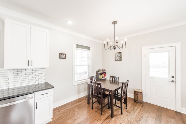 dining room featuring light hardwood / wood-style flooring, ornamental molding, and a notable chandelier