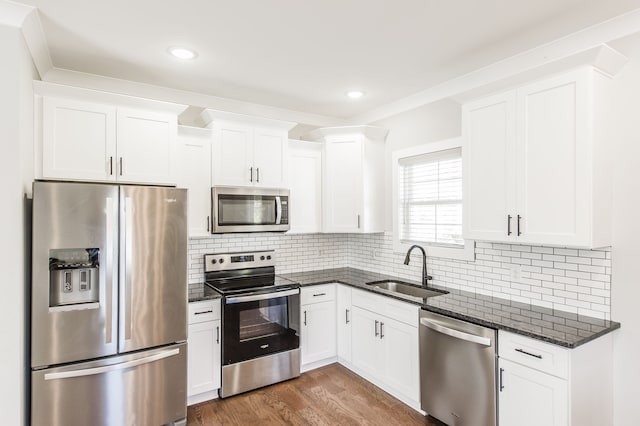 kitchen with dark stone countertops, sink, white cabinets, and appliances with stainless steel finishes