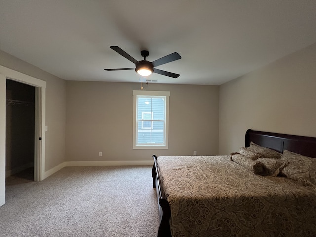 carpeted bedroom with a closet, a spacious closet, and ceiling fan