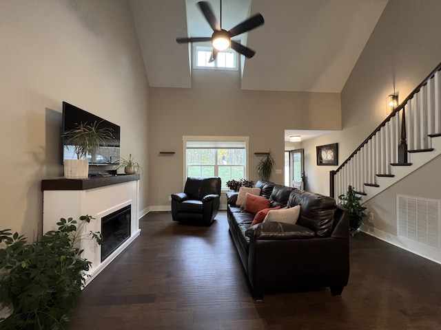 living room with dark hardwood / wood-style floors, ceiling fan, and high vaulted ceiling