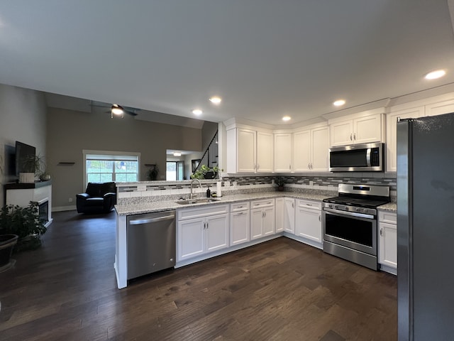 kitchen with white cabinets, appliances with stainless steel finishes, dark hardwood / wood-style flooring, and sink