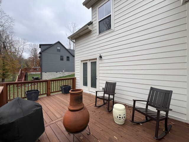 wooden terrace featuring a grill