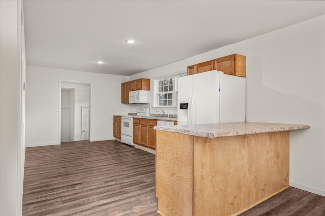 kitchen featuring kitchen peninsula, sink, dark wood-type flooring, and white appliances