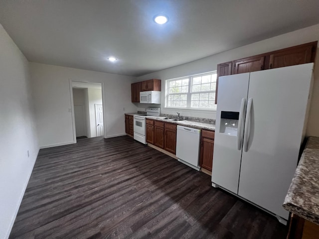 kitchen featuring white appliances, dark hardwood / wood-style floors, and sink