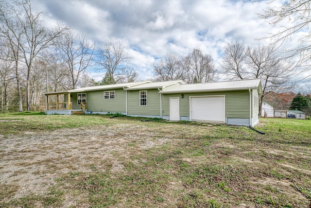 rear view of property featuring a lawn and a garage