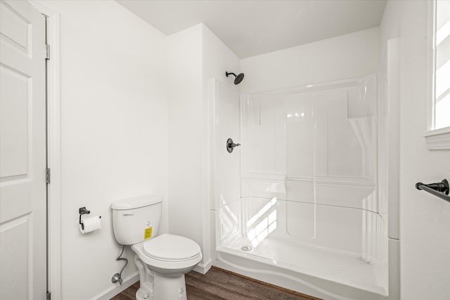 bathroom with a shower, toilet, and hardwood / wood-style flooring