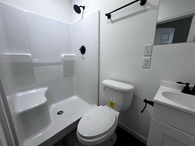 bathroom with vanity, toilet, and a shower