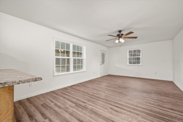 unfurnished living room with ceiling fan and wood-type flooring