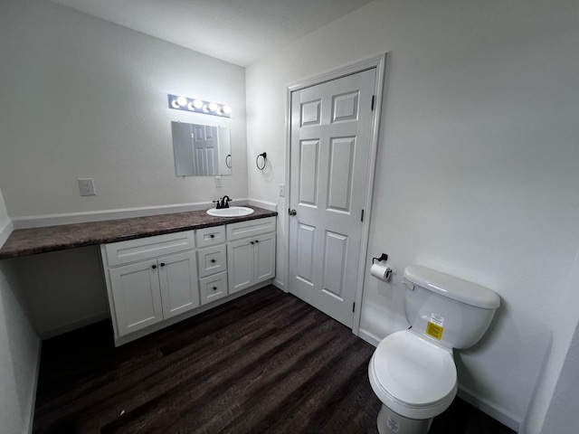 bathroom featuring wood-type flooring, vanity, and toilet