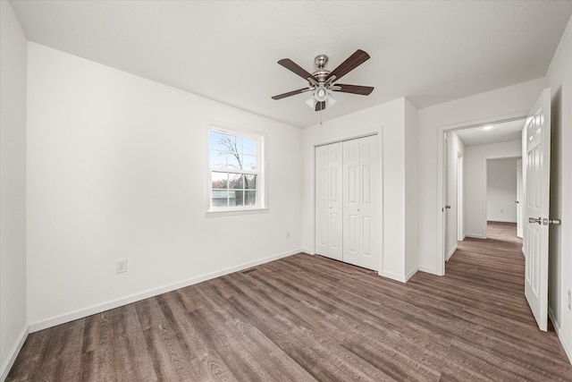 unfurnished bedroom featuring a closet, ceiling fan, and dark hardwood / wood-style flooring