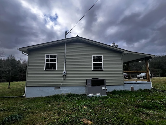 view of side of home featuring covered porch and a yard