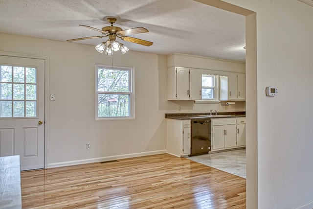 kitchen featuring light hardwood / wood-style flooring, dishwasher, white cabinets, and plenty of natural light