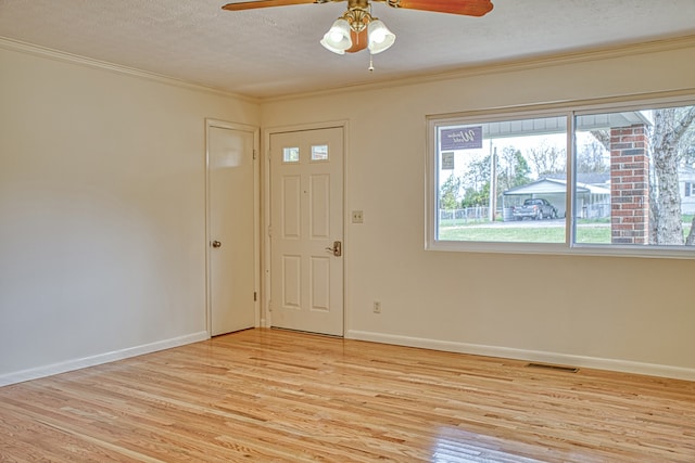 foyer featuring a textured ceiling, light hardwood / wood-style floors, ceiling fan, and ornamental molding