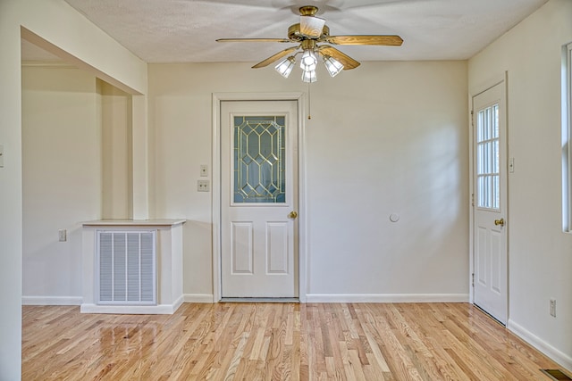 foyer entrance featuring ceiling fan, light wood-type flooring, and a textured ceiling