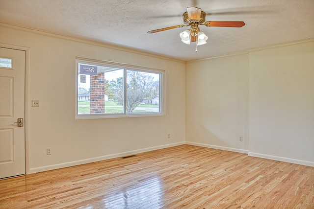 unfurnished room featuring ornamental molding, ceiling fan, light wood-type flooring, and a textured ceiling