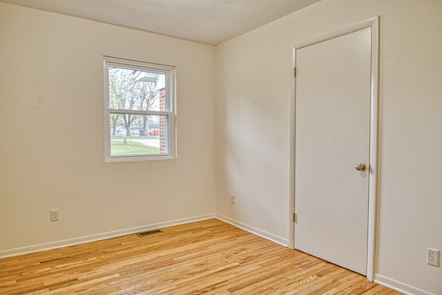 spare room with light hardwood / wood-style flooring and a textured ceiling