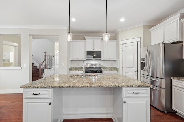 kitchen with hanging light fixtures, light stone counters, dark hardwood / wood-style floors, a center island with sink, and appliances with stainless steel finishes