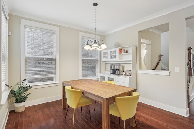 dining room with a wealth of natural light, a chandelier, crown molding, and dark wood-type flooring