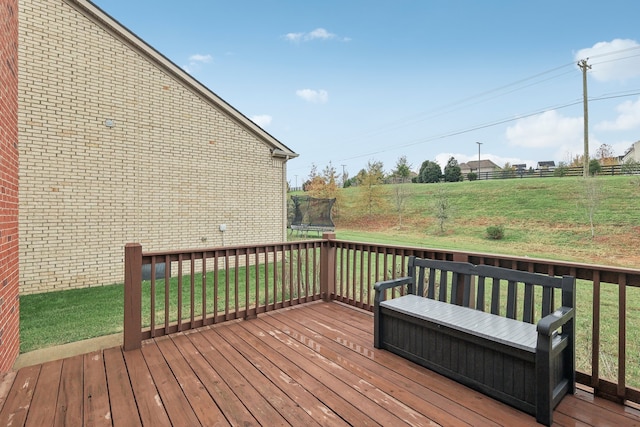 wooden deck featuring a lawn and a trampoline