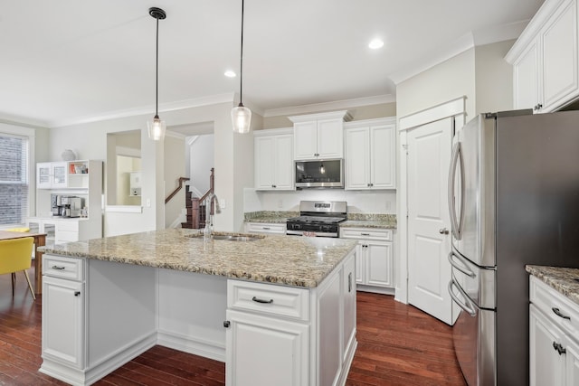 kitchen with dark hardwood / wood-style flooring, stainless steel appliances, sink, pendant lighting, and an island with sink