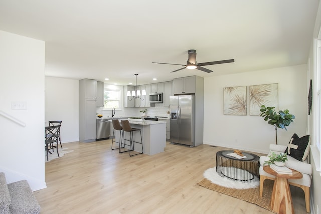 living room featuring light hardwood / wood-style flooring, ceiling fan, and sink