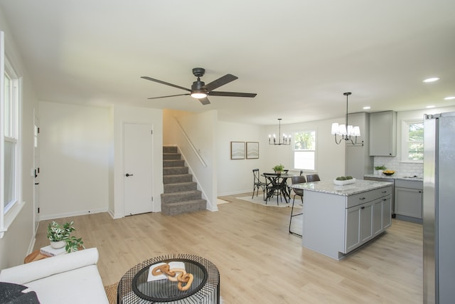 kitchen featuring stainless steel refrigerator, gray cabinetry, light hardwood / wood-style flooring, and a center island