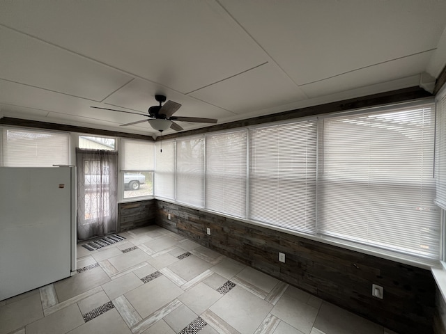 unfurnished sunroom with ceiling fan