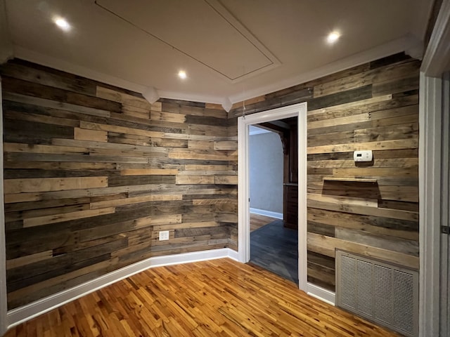 spare room featuring hardwood / wood-style flooring and wooden walls