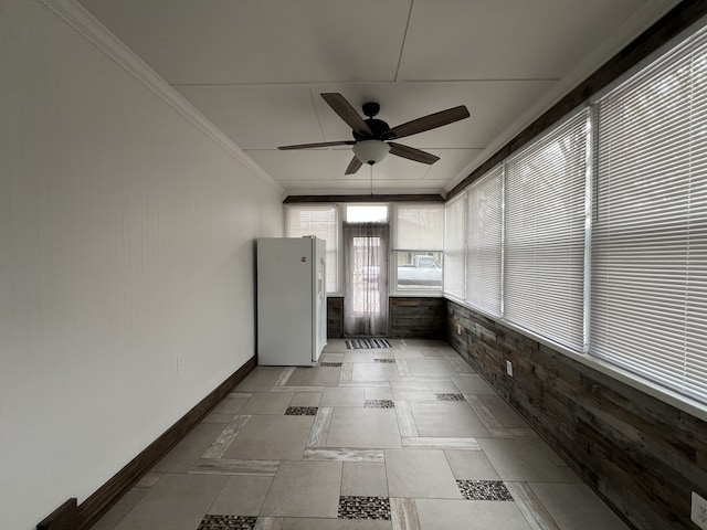 unfurnished sunroom featuring ceiling fan