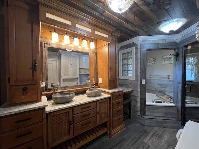 bathroom featuring tiled tub, crown molding, and vanity