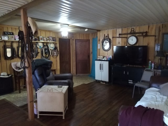 living room with wood walls, ceiling fan, and dark wood-type flooring