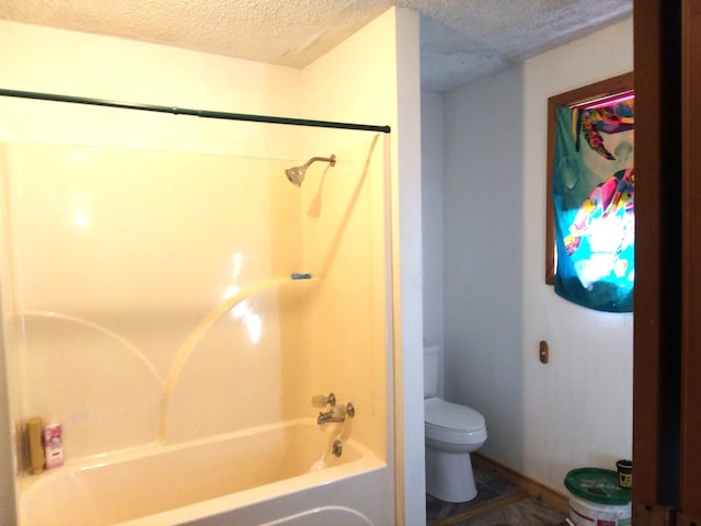 bathroom featuring tub / shower combination, a textured ceiling, and toilet