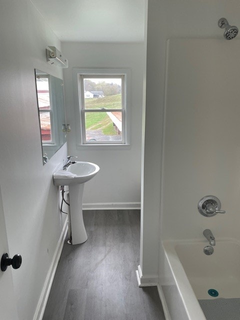 bathroom with shower / bath combination, sink, and wood-type flooring