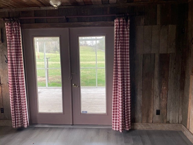 doorway to outside featuring a wealth of natural light, french doors, light hardwood / wood-style floors, and wooden ceiling