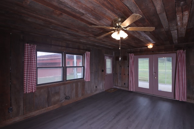 unfurnished room with wood walls, wooden ceiling, french doors, ceiling fan, and wood-type flooring