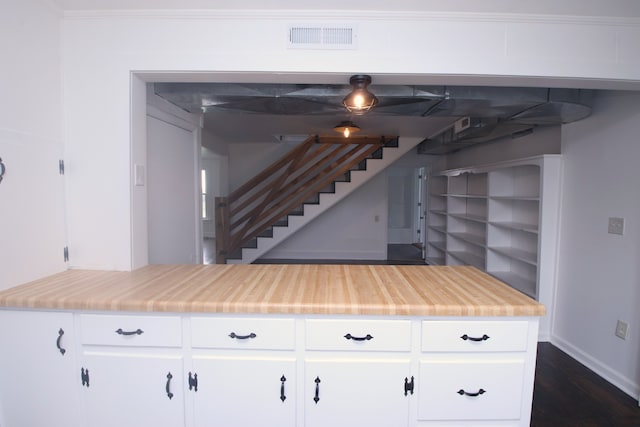 kitchen featuring crown molding, dark hardwood / wood-style flooring, and white cabinets