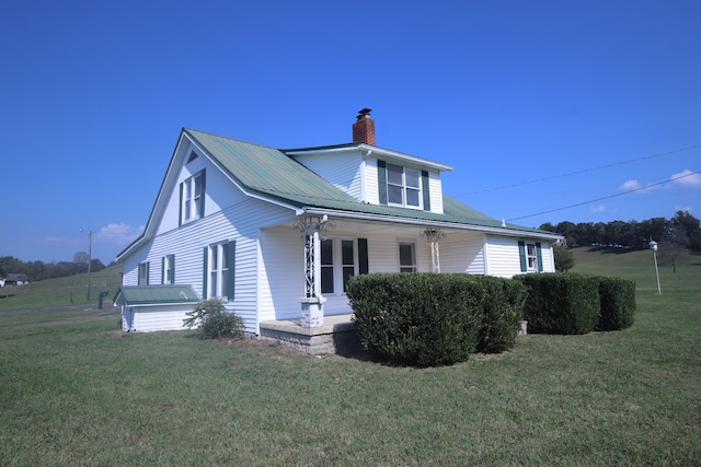 view of side of property with a porch and a yard