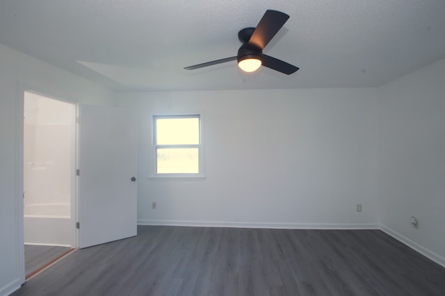 empty room with a textured ceiling, ceiling fan, and dark hardwood / wood-style floors