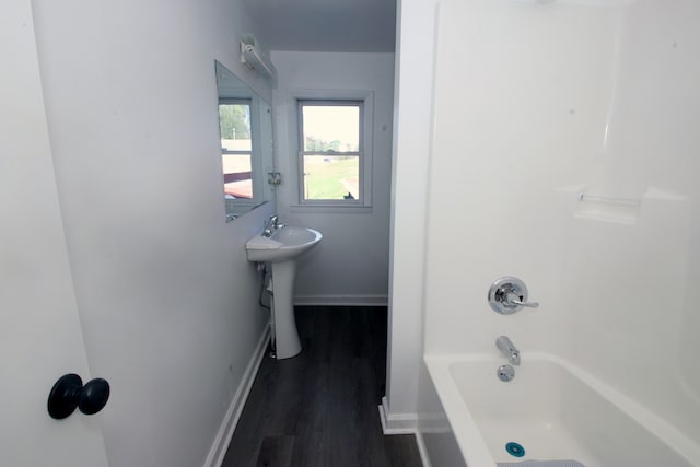 bathroom with sink, wood-type flooring, and washtub / shower combination