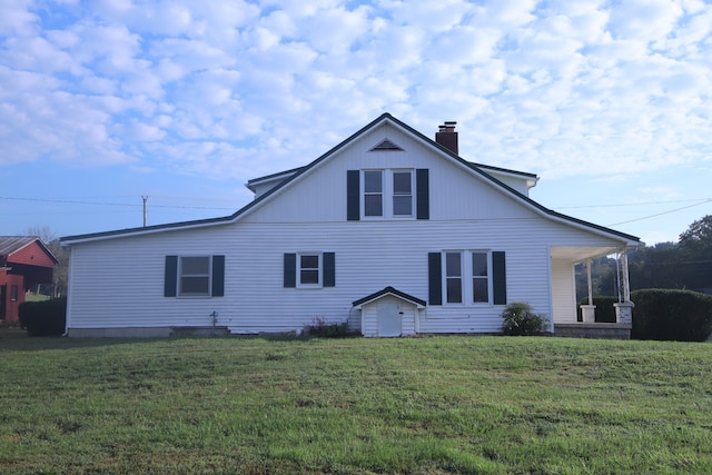 back of house featuring covered porch and a yard