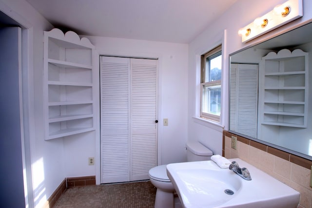 bathroom featuring decorative backsplash, tile patterned floors, and toilet