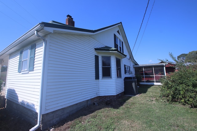 view of home's exterior featuring a lawn, a sunroom, and cooling unit