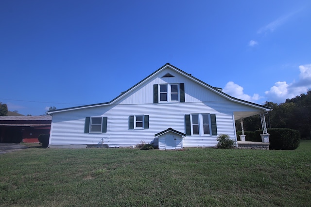 rear view of house featuring a yard