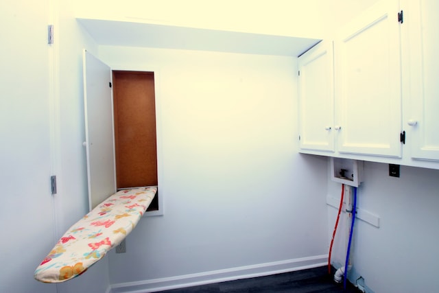 washroom featuring cabinets, dark wood-type flooring, and hookup for a washing machine