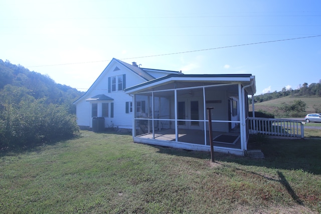 back of house with a lawn and a sunroom