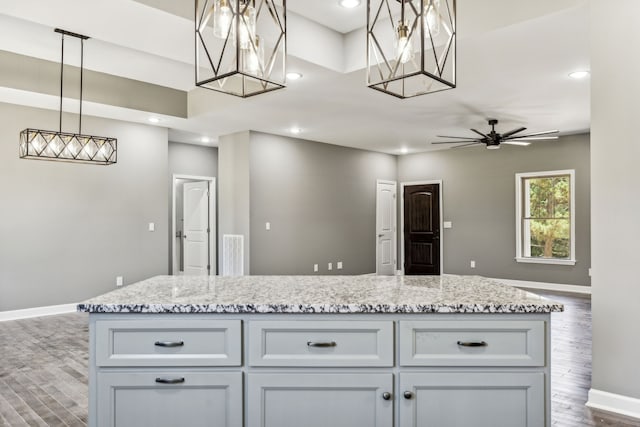 kitchen featuring white cabinetry, a center island, ceiling fan, dark hardwood / wood-style floors, and pendant lighting