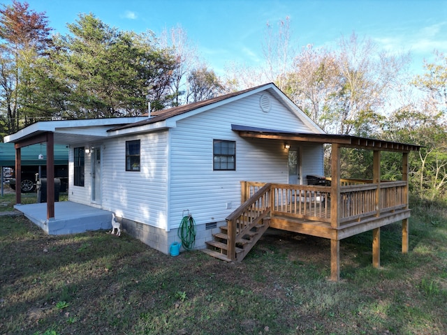 back of house featuring a yard, a patio area, and a wooden deck