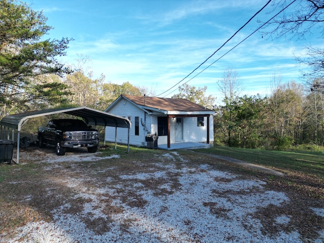 view of front of home featuring covered porch, a front yard, and a carport