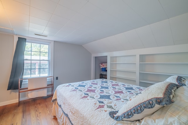 bedroom with hardwood / wood-style floors and lofted ceiling