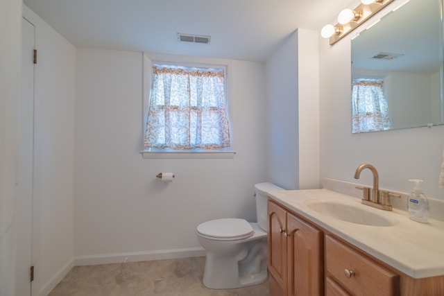 bathroom with tile patterned flooring, vanity, and toilet